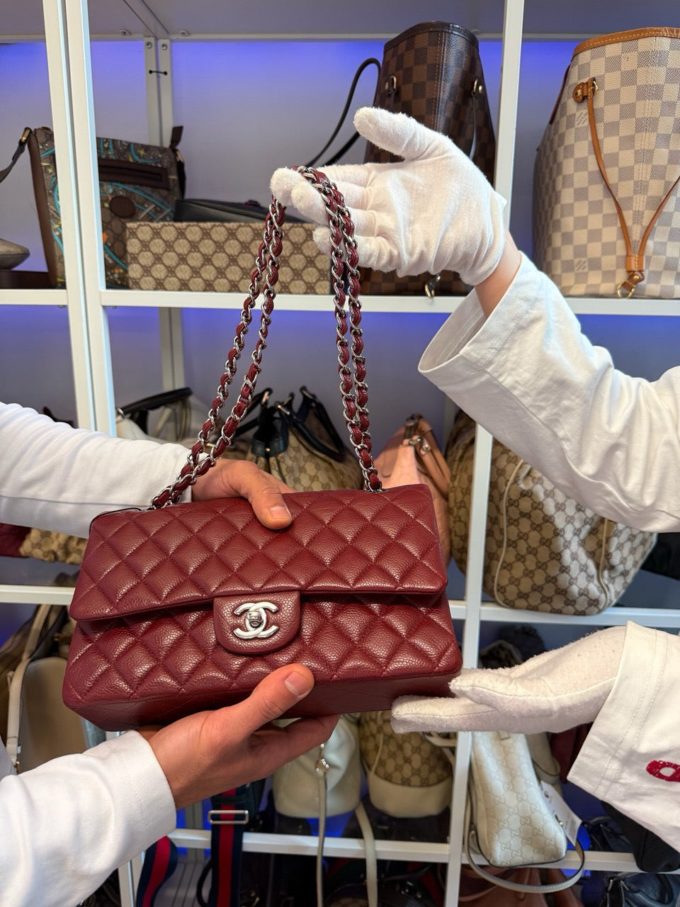 Rote Chanel Classic Flap Bag wird mit Handschuhen übergeben – mit Entrupy Zertifikat