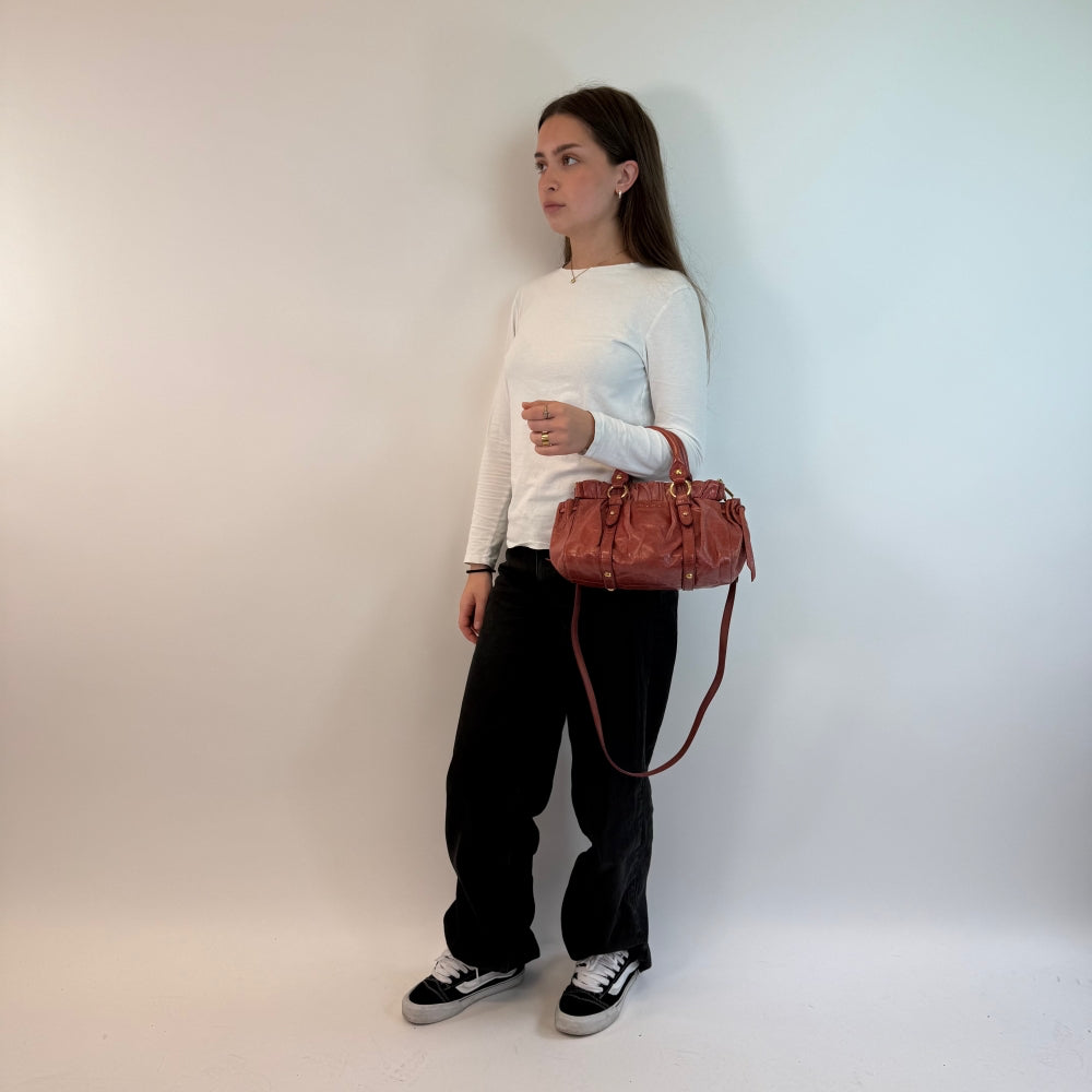 Miu Miu Handtasche Vitello Lux klein mit Umhängegurt aus Leder rot / rosa
