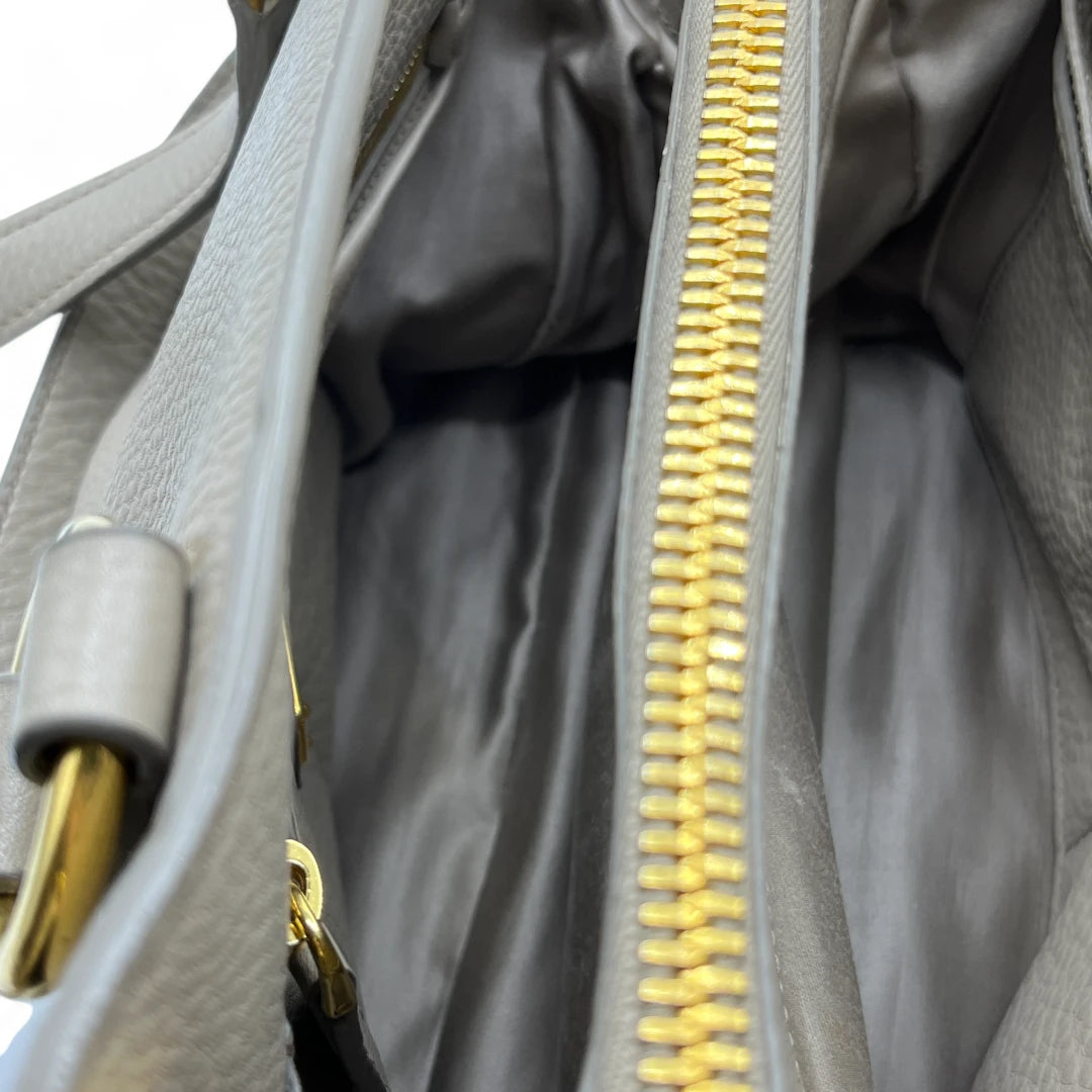 Miu Miu Handtasche Vitello mit Umhängegurt aus Leder grau